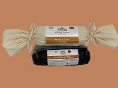 Two apricot and ginger  log puddings one wrapped in calico with ribbon and the other vacuum sealed with labels on