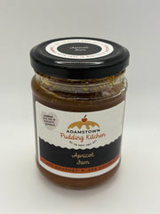 Jar of Adamstown Pudding Kitchen apricot jam on a white background