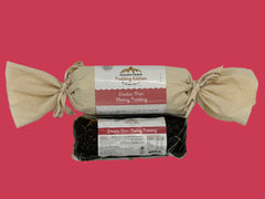 Two packages of Double Choc Cherry Pudding one log wrapped in calico with ribbon and the other in a vacuum sealed bag from Adamstown Pudding Kitchen on a white background.
