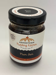 Jar of Adamstown Pudding Kitchen plum jam on a white background