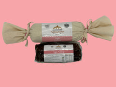 Two packages of Adamstown Pudding Kitchen vegan pudding on a white background one gift wrapped in calico and once just in a vacuum sealed bag